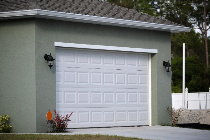 White traditional raised-panel garage door on a residential home